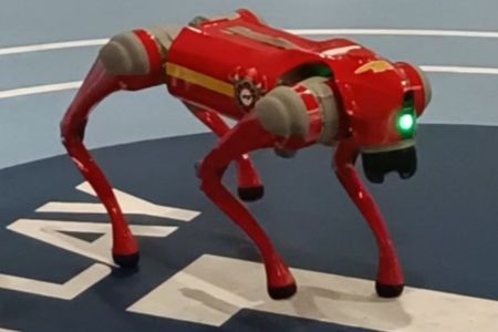 A robotic dog awaits input from a student on a school trip to South Korea