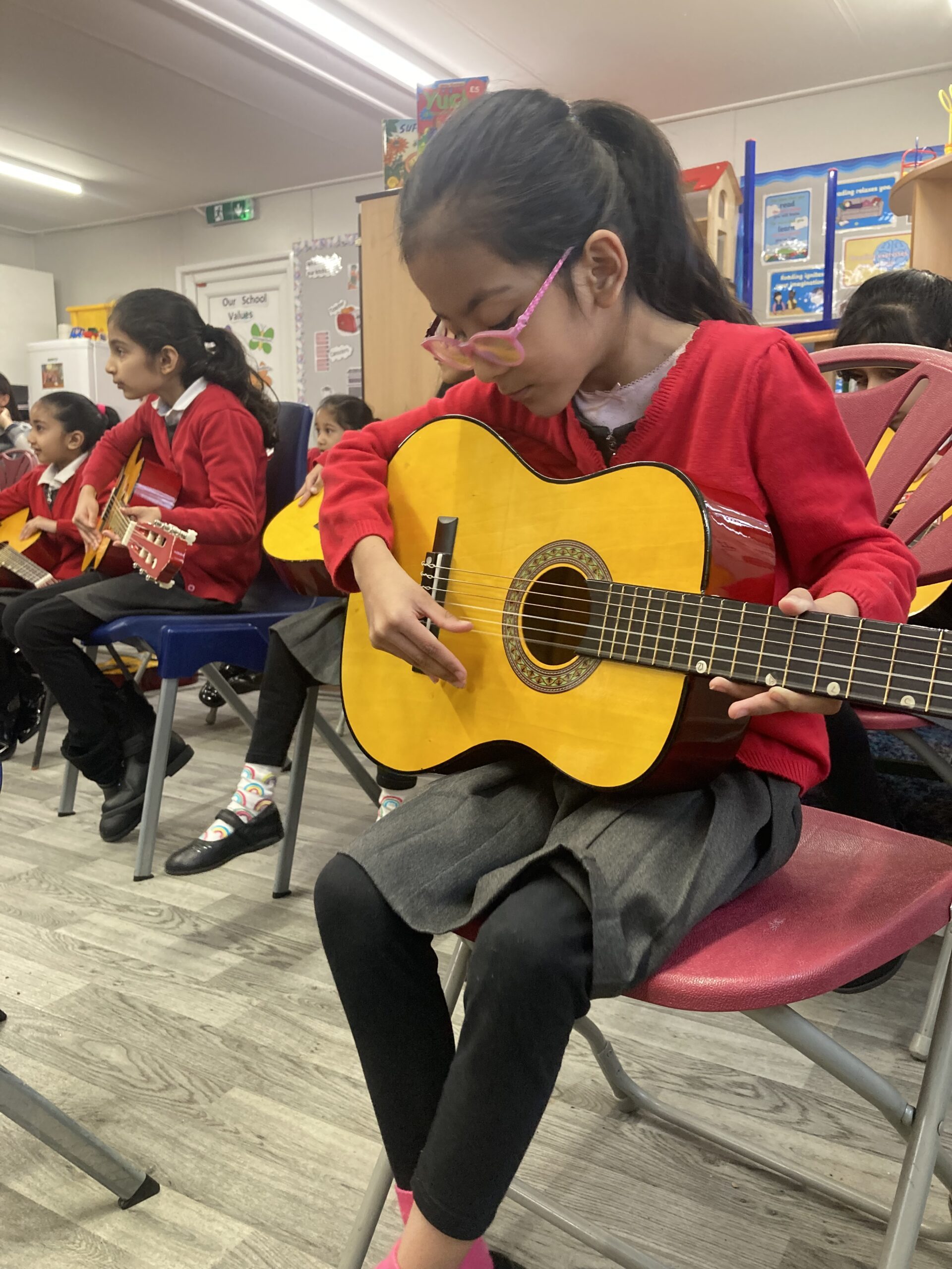 Child playing guitar in schools