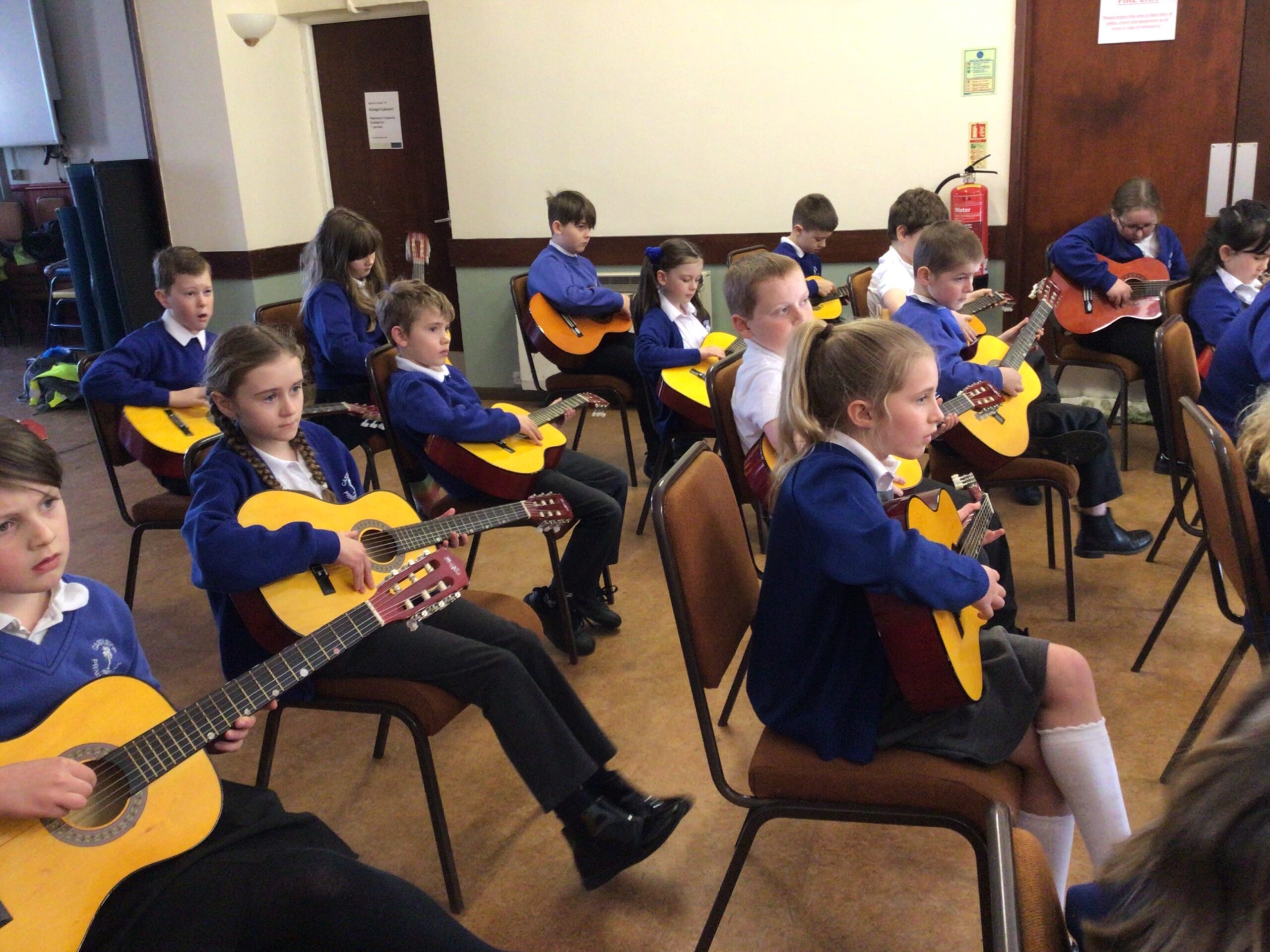 Children enjoying guitar playing in schools