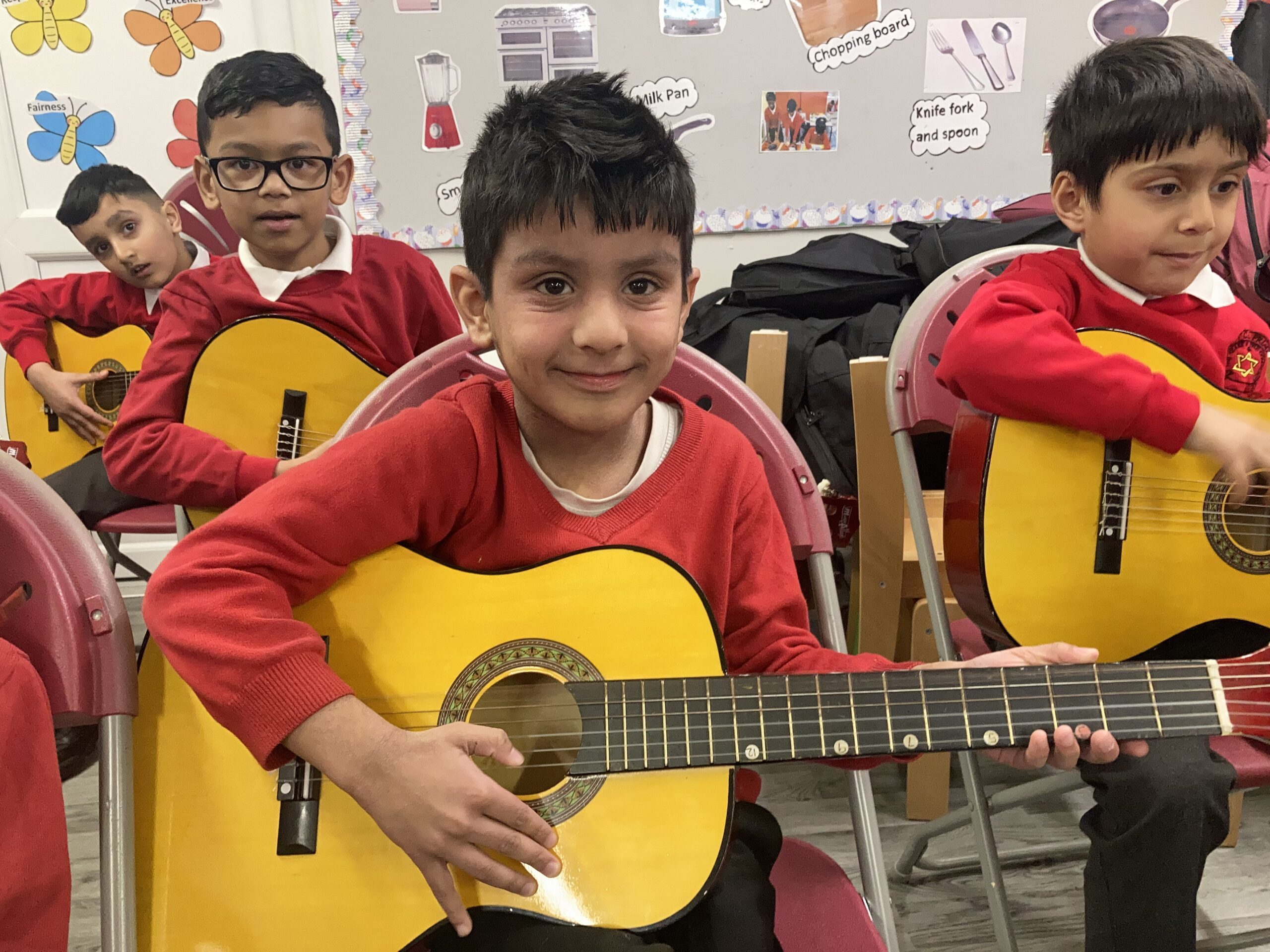 Happy children with guitars in school